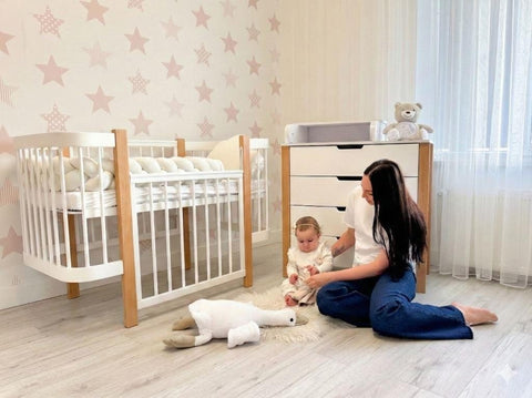 1. Woman and child playing in nursery with KOTTO ELIN baby crib in natural and white, star wallpaper