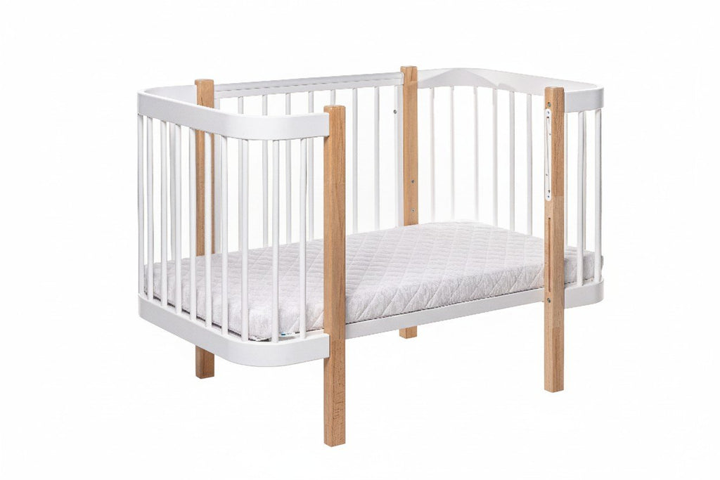 2. KOTTO ELIN baby crib in natural and white beechwood with orthopedic slatted base, shown in studio setting