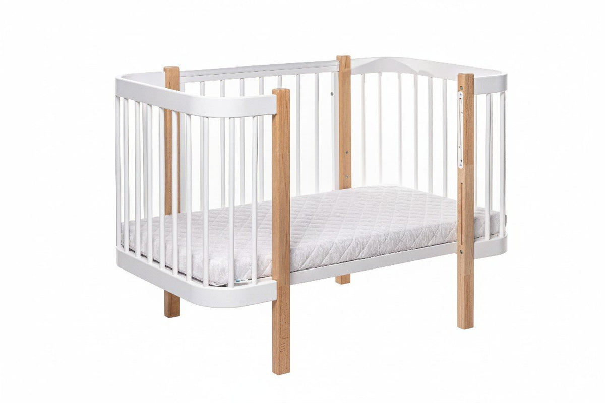 2. KOTTO ELIN baby crib in natural and white beechwood with orthopedic slatted base, shown in studio setting