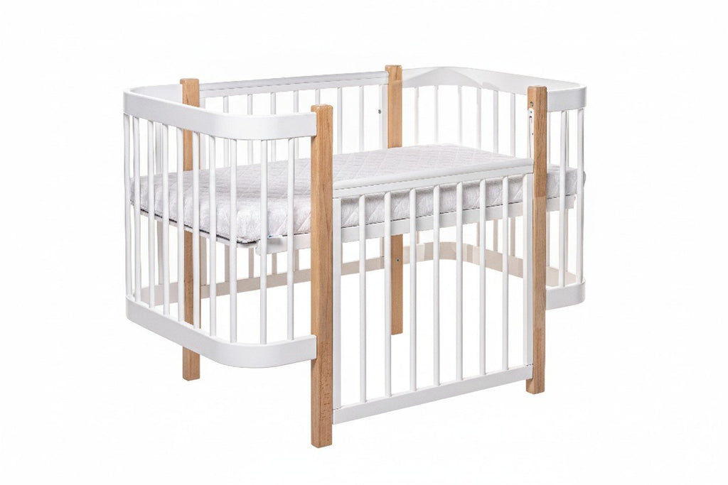 2. KOTTO ELIN baby crib in natural and white beechwood with orthopedic slatted base, shown in studio setting