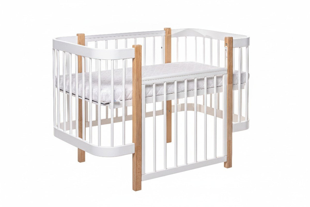 2. KOTTO ELIN baby crib in natural and white beechwood with orthopedic slatted base, shown in studio setting