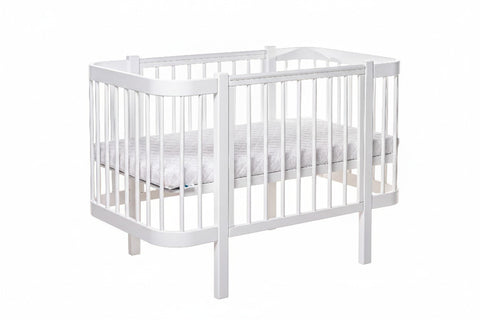 2. White KOTTO ELIN baby crib with mattress in studio setting, showcasing stable design without drawer
