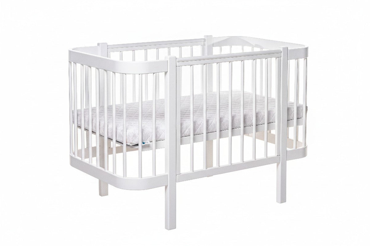 2. White ELIN baby crib with removable side panel and slatted base in studio setting