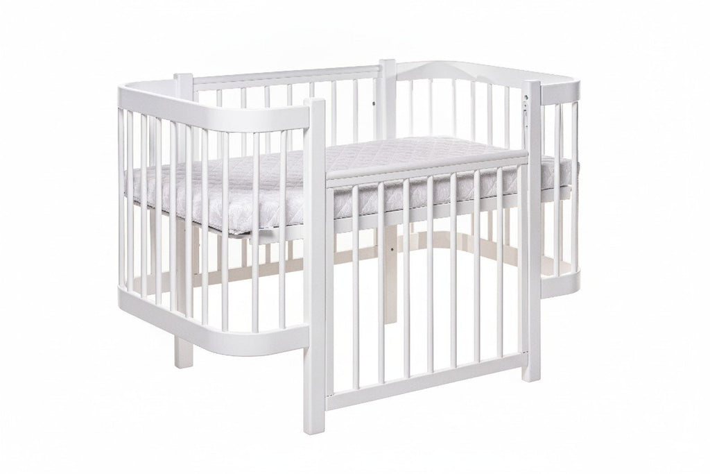 2. White ELIN baby crib with rounded edges and teething guards in studio setting