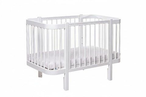 2. White KOTTO ELIN baby crib with mattress in studio setting, highlighting rounded edges and teething guards