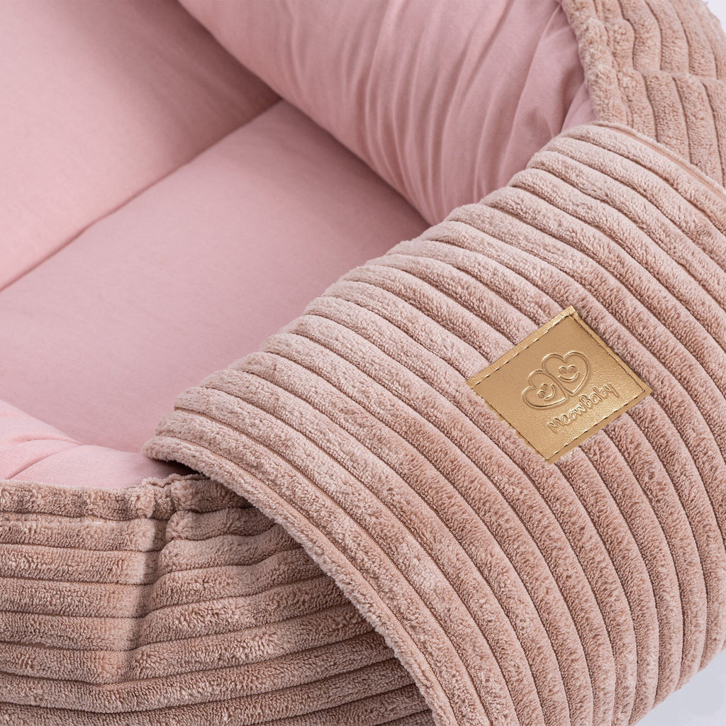 3. Close-up of MeowBaby logo on ribbed fabric of powder pink baby nest, showing texture detail