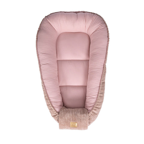 2. Top view of powder pink baby nest with cushioned edges and ribbed fabric, highlighting the soft interior