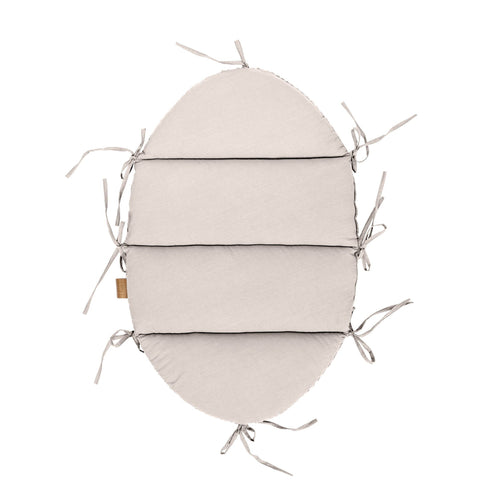 4. Flat lay of ecru baby nest mat with fabric ties, top view