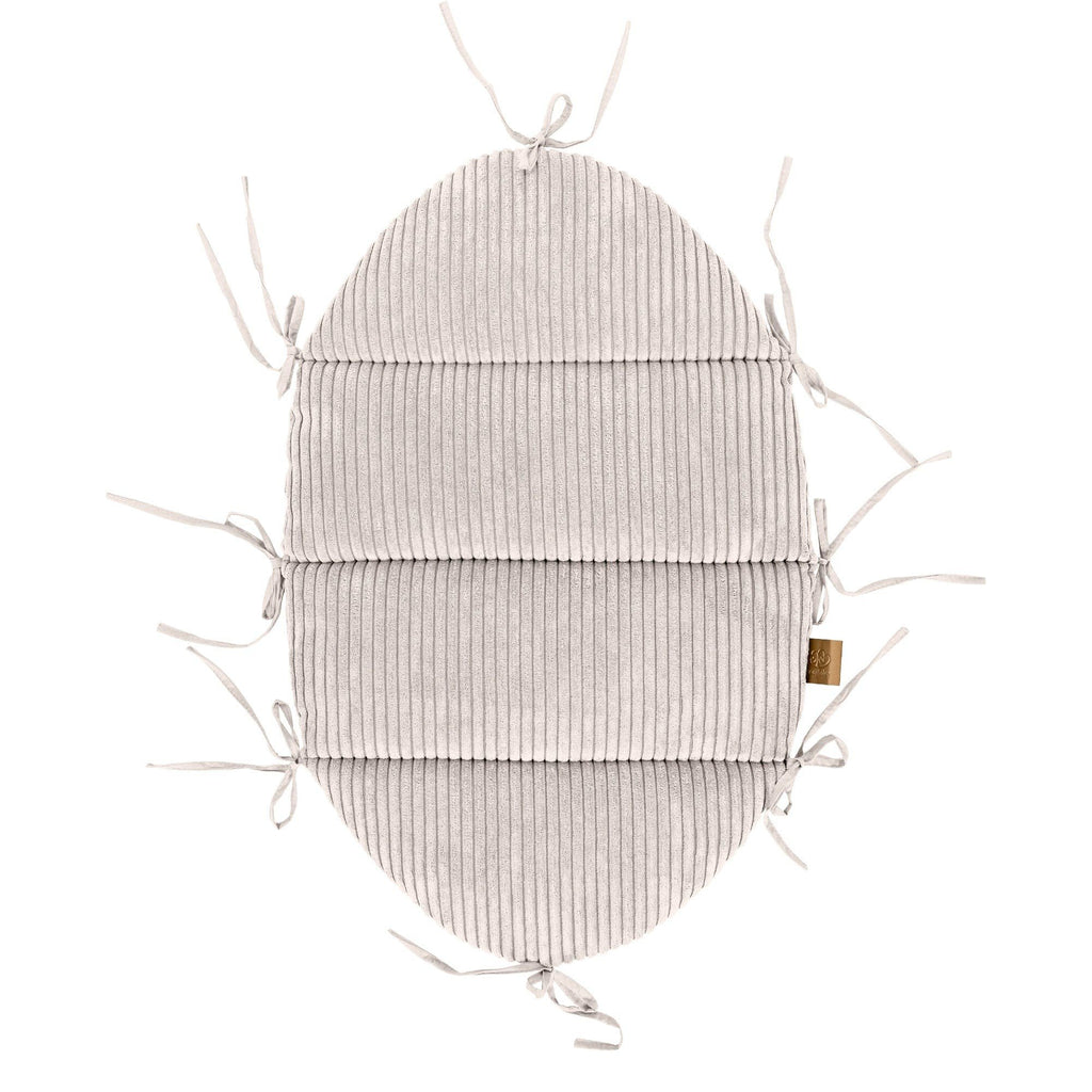 4. Flat lay of ecru baby nest mat in corduroy with fabric ties, bottom view