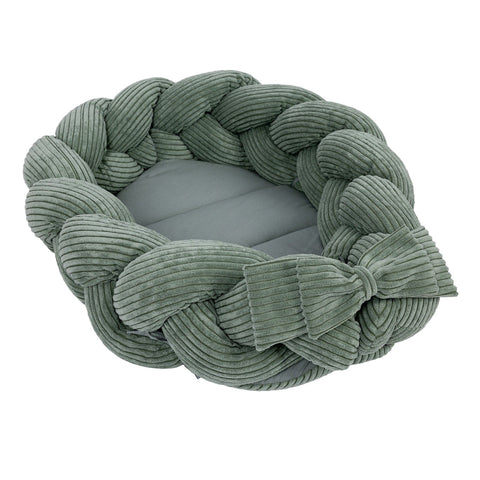1. Olive green baby nest with braided bumper made of soft corduroy, shown in a circular shape with a bow detail