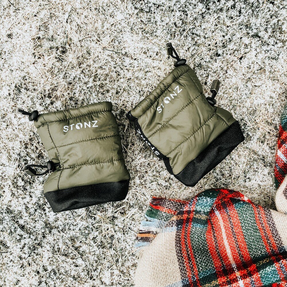 1. Green Stonz Puffer Booties with black soles on snowy ground next to plaid blanket