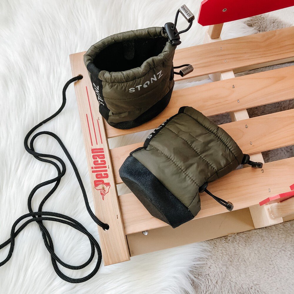 3. Close-up of green Stonz Puffer Booties on wooden sled with black soles and elastic straps