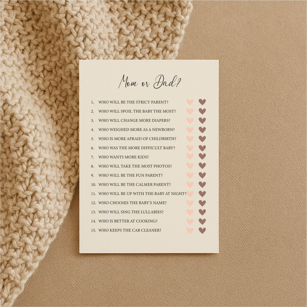 2. Single Beebila baby shower game card with 'Mom or Dad?' questions on cream Munken Pure paper, resting on a textured beige surface