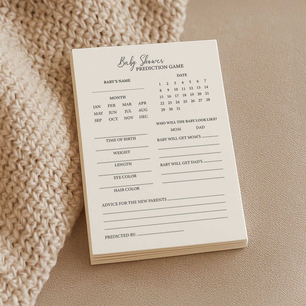 1. Stack of Beebila baby shower prediction game cards on beige knitted fabric, featuring sections for baby's name, birth details, and advice, printed on thick cream Munken Pure paper.