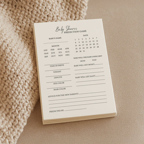 1. Stack of Beebila baby shower prediction game cards on beige knitted fabric, featuring sections for baby's name, birth details, and advice, printed on thick cream Munken Pure paper.