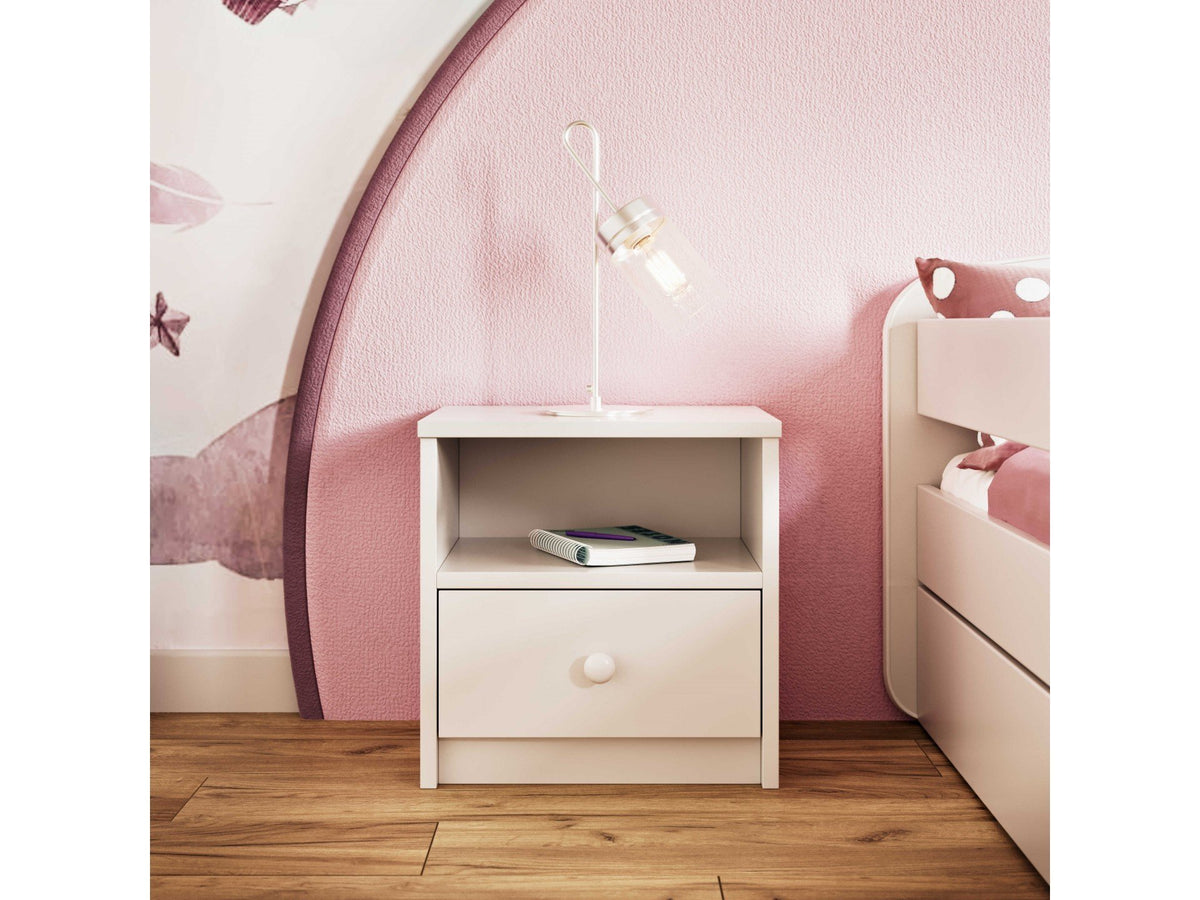 8. White bedside table with open shelf and drawer, styled with a lamp in a pink-themed room