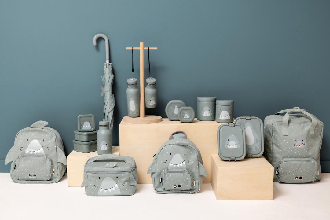 1. Collection of grey shark-themed backpacks and accessories on display against a blue wall