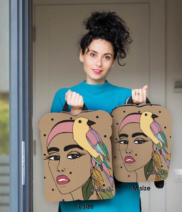 4. Woman holding Garbanota BACKPACK JURATE in L and M sizes, featuring unique artwork and smooth fabric