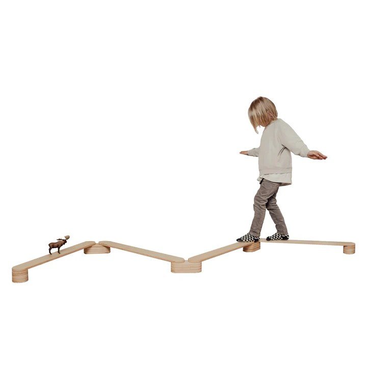 2. Child walking on zigzag wooden balance beams against a white background, enhancing balance and coordination
