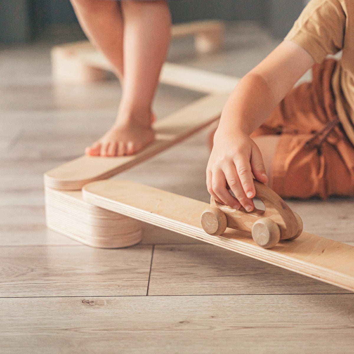 3. Close-up of child's hand holding a wooden toy car on leg&go balance beams