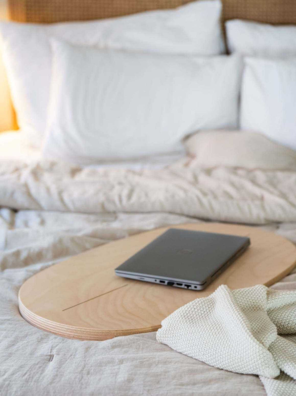 4. Flat lay of leg&go balance board used as a laptop desk on a bed with soft linens
