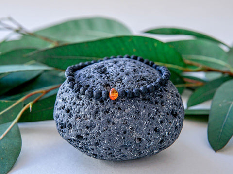 5. Men's Baltic Amber and Black Lava Bracelet by Canary Lava on volcanic rock, showcasing natural volcanic origin