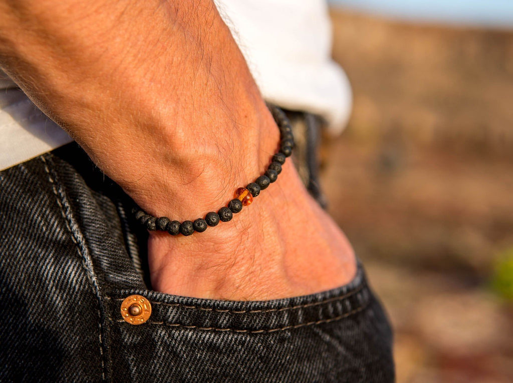 1. Men's Baltic Amber and Black Lava Bracelet by Canary Lava worn on wrist, showcasing natural elegance and aromatherapy benefits