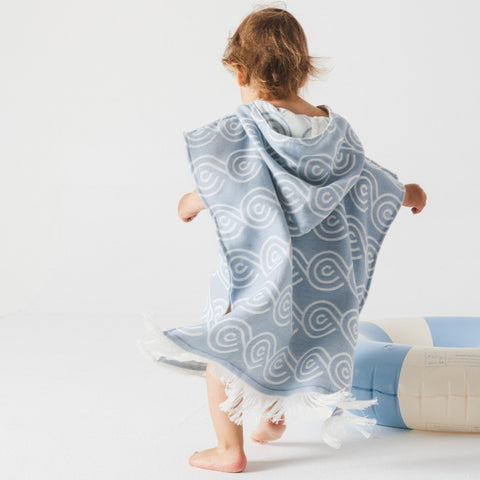 3. Child wearing light blue Patulove bamboo bath poncho with hood, shown from back, near inflatable pool ring