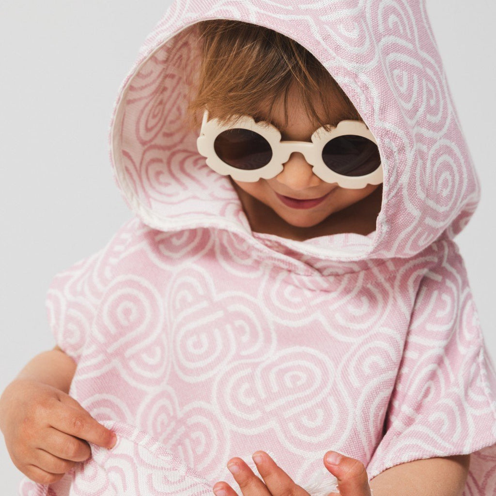 4. Close-up of child wearing Patulove rose bamboo bath poncho with hood and sunglasses, smiling
