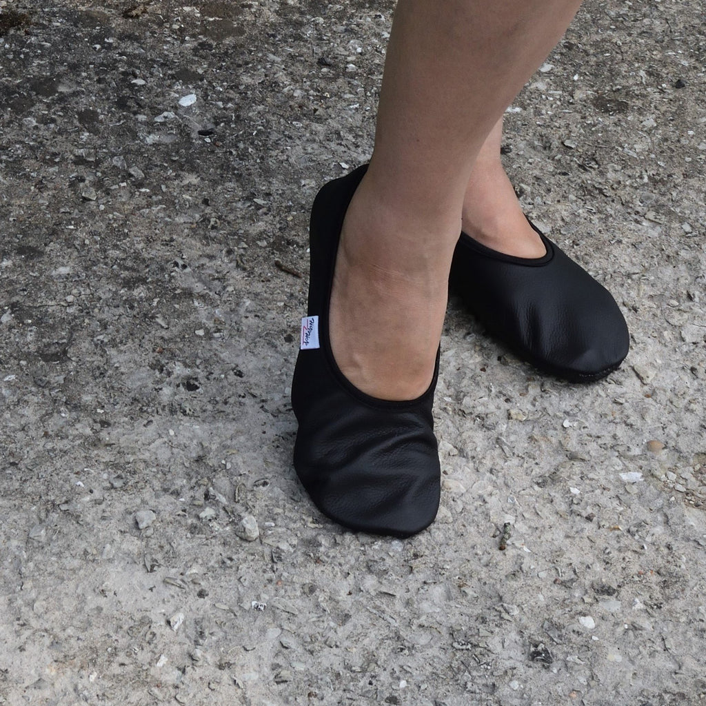 3. Black leather barefoot slippers by Hip-Hop worn outdoors on concrete