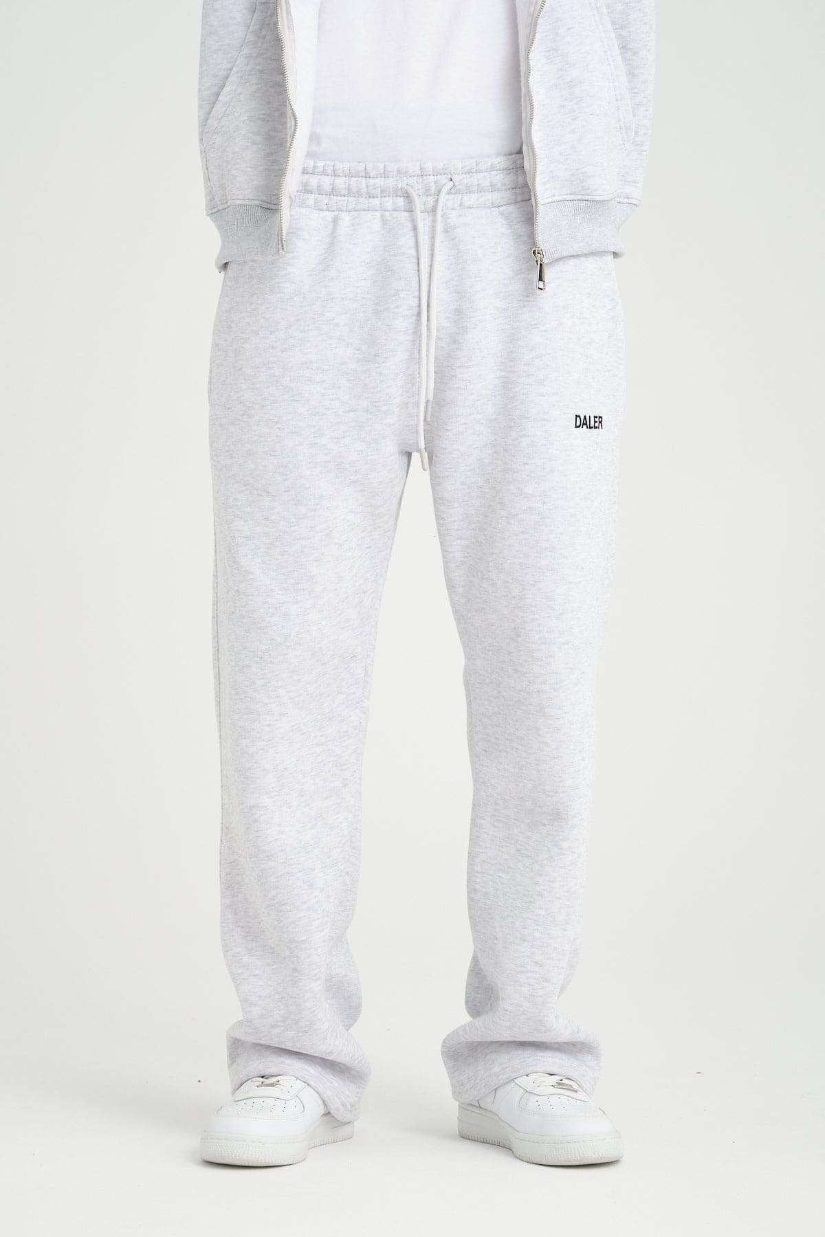 2. Front view of grey melange jogger pants with DALER logo and drawstring waist, paired with white sneakers