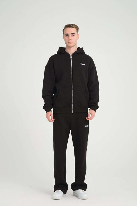 2. Full-body view of man in black DalerClo heavyweight zipper hoodie and matching pants, studio setting