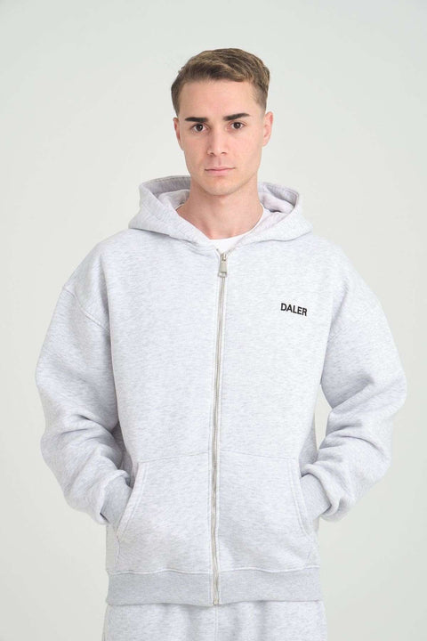 1. Man wearing grey melange DalerClo hoodie with DALER embroidery, hands in pockets, studio setting