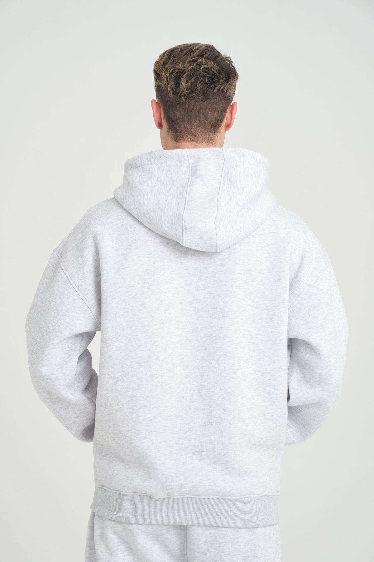 2. Back view of grey melange DalerClo hoodie worn by man, showing hood and relaxed fit