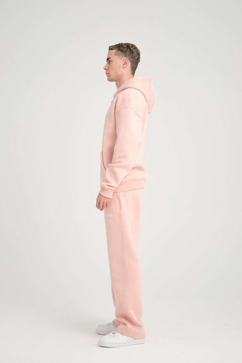 1. Side profile of man in pink oversized zipper hoodie and pants, studio background