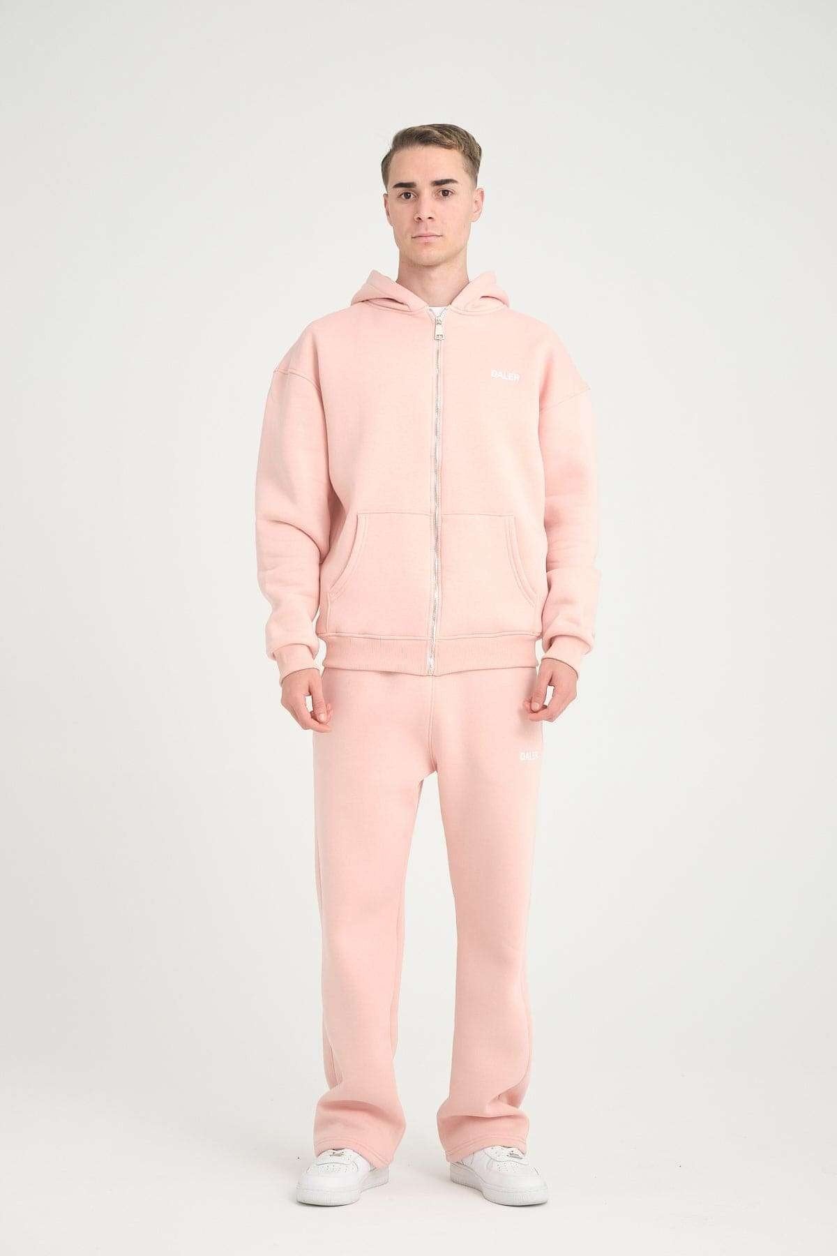 1. Full-body view of man in pink oversized zipper hoodie and matching pants, studio setting