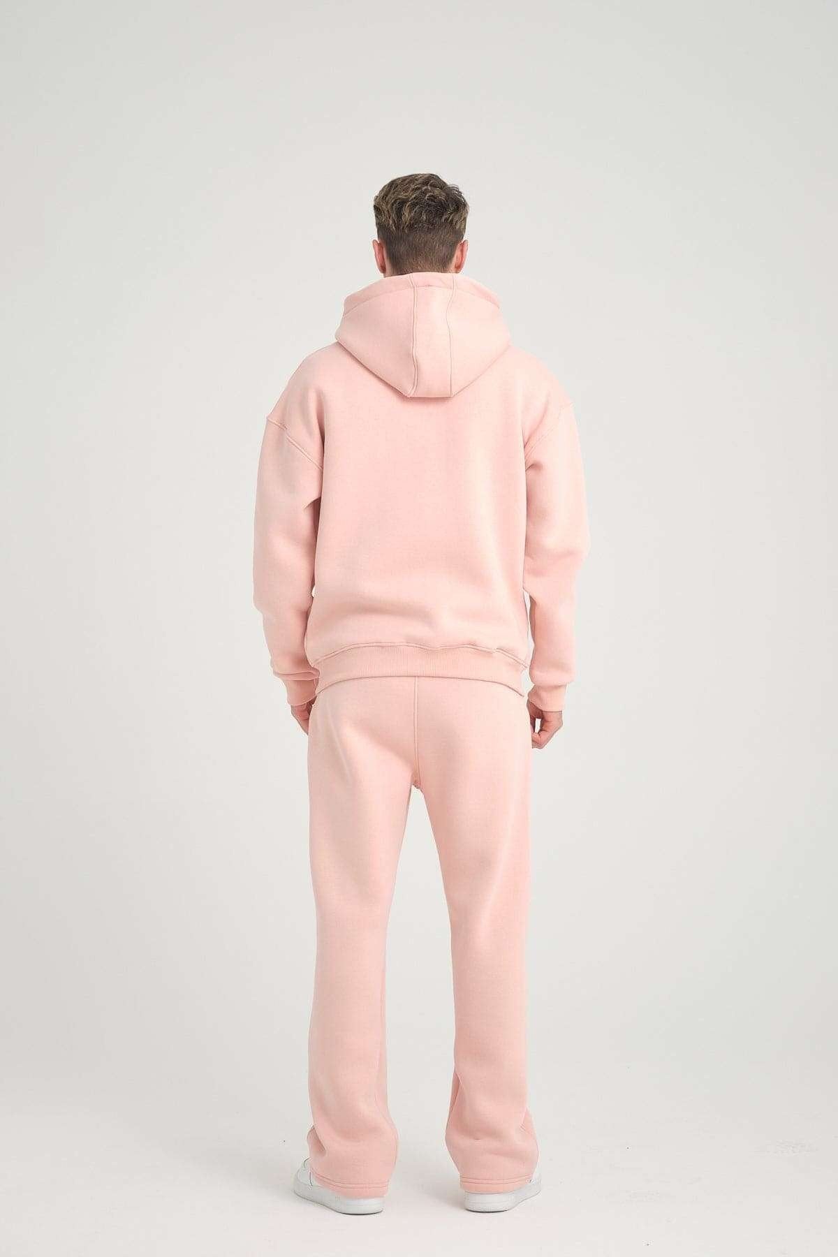 1. Back view of man wearing pink oversized zipper hoodie and pants, studio setting