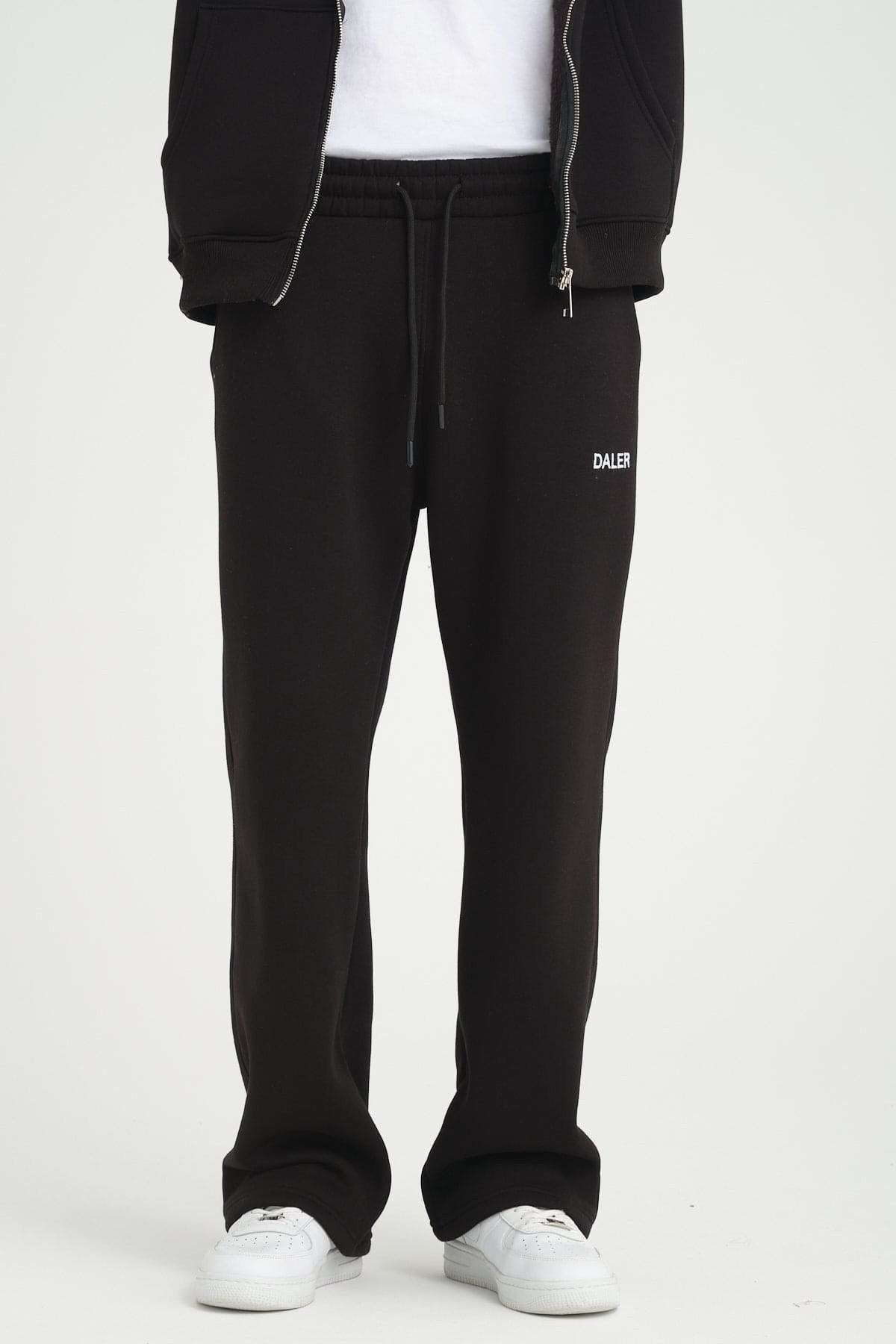 1. Men's black jogger pants with DALER embroidery, shown from front with white sneakers in studio setting