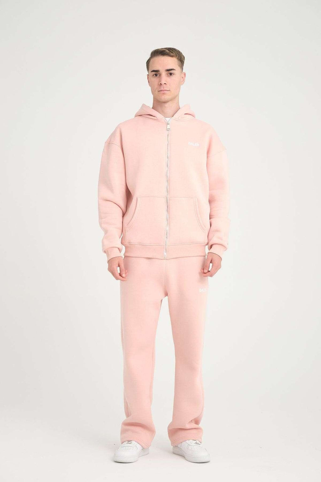 1. Man in pink jogger pants and hoodie facing forward in studio