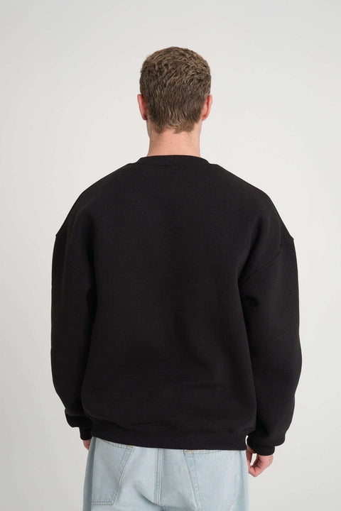 2. Back view of man wearing black oversized DalerClo sweatshirt showing shoulder detail