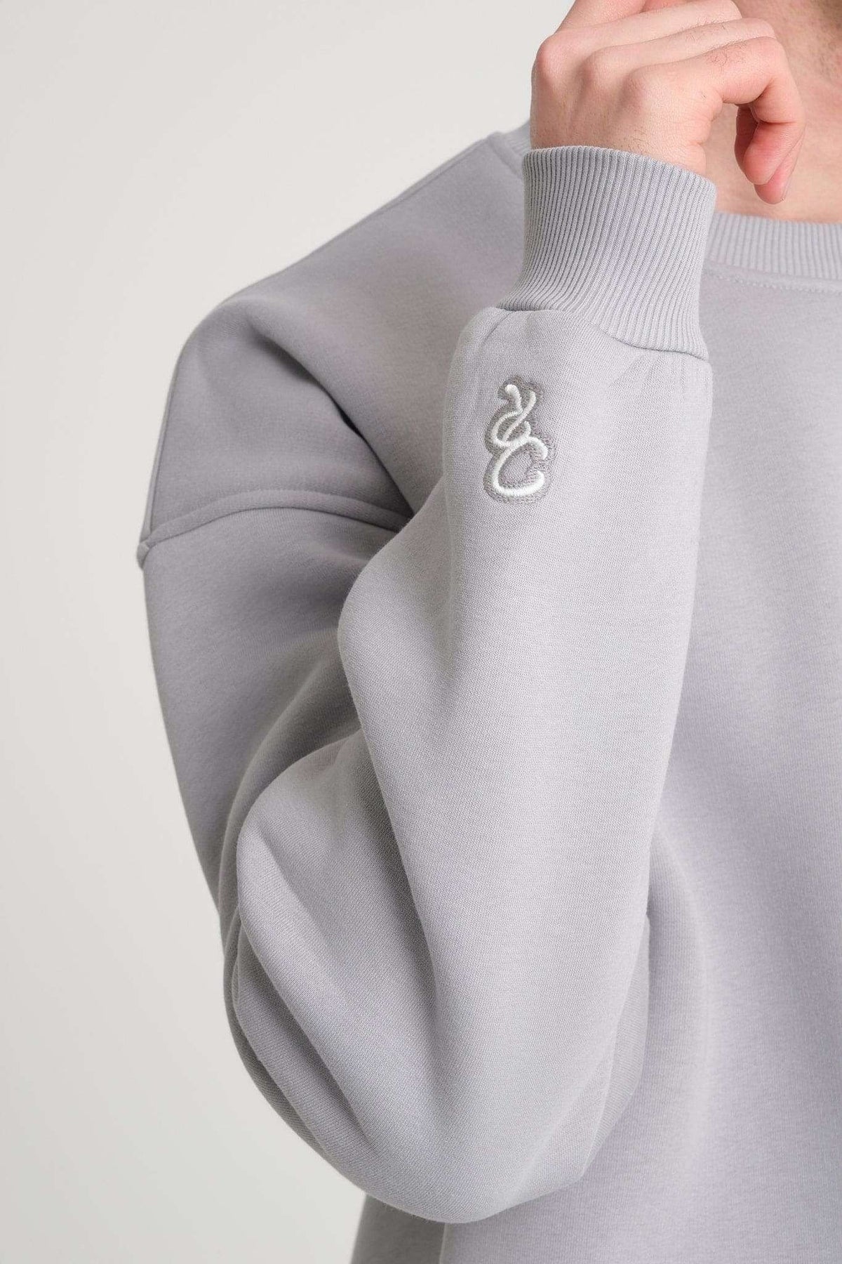 3. Close-up of grey DalerClo sweatshirt sleeve with distinctive white embroidery