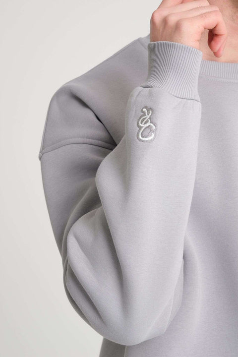 3. Close-up of grey DalerClo sweatshirt sleeve with distinctive white embroidery