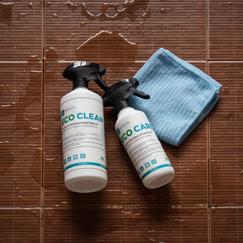 4. Flat lay of GoGoNano EcoClean and EcoCare bottles with blue cloth on wet brown tiles, emphasizing cleaning effectiveness