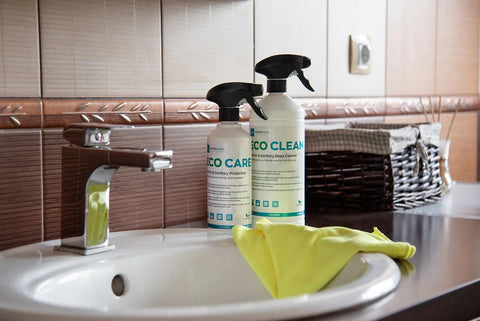 1. GoGoNano EcoClean and EcoCare bottles on bathroom counter with yellow cloth, showcasing eco-friendly cleaning solutions