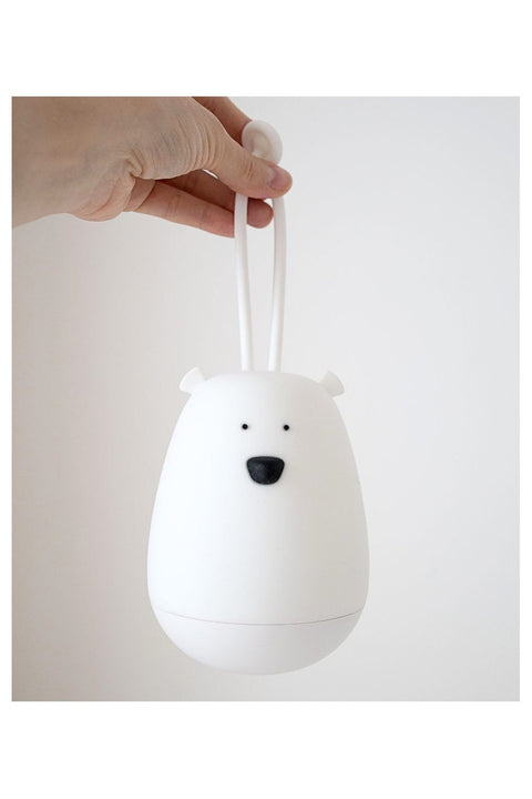 5. Hand holding a white bear-shaped night light against a plain white background