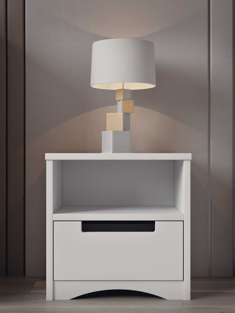 1. White bedside table with lamp on top, in a stylish room setting with wooden panel background