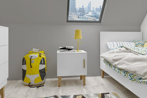 1. Kocot Kids Kubi white bedside table in a modern bedroom with a yellow lamp and city view