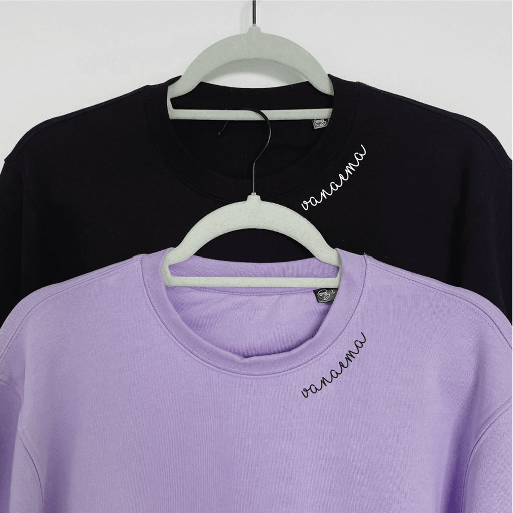 3. Black and lilac Beebila 'Vanaema' sweatshirts with embroidered collars on hangers, studio setting