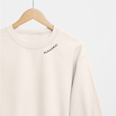 2. Beige Beebila 'Vanaema' sweatshirt with embroidered collar on hanger, studio setting