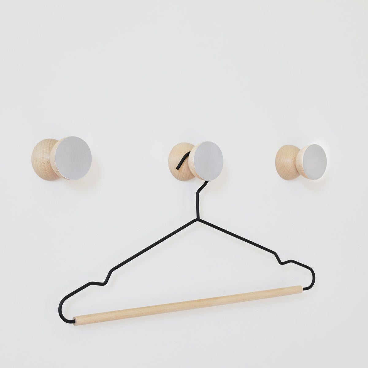 2. Studio shot of 5mm Paper Beech Wood & Aluminium Wall Hooks with a hanger, showcasing versatility